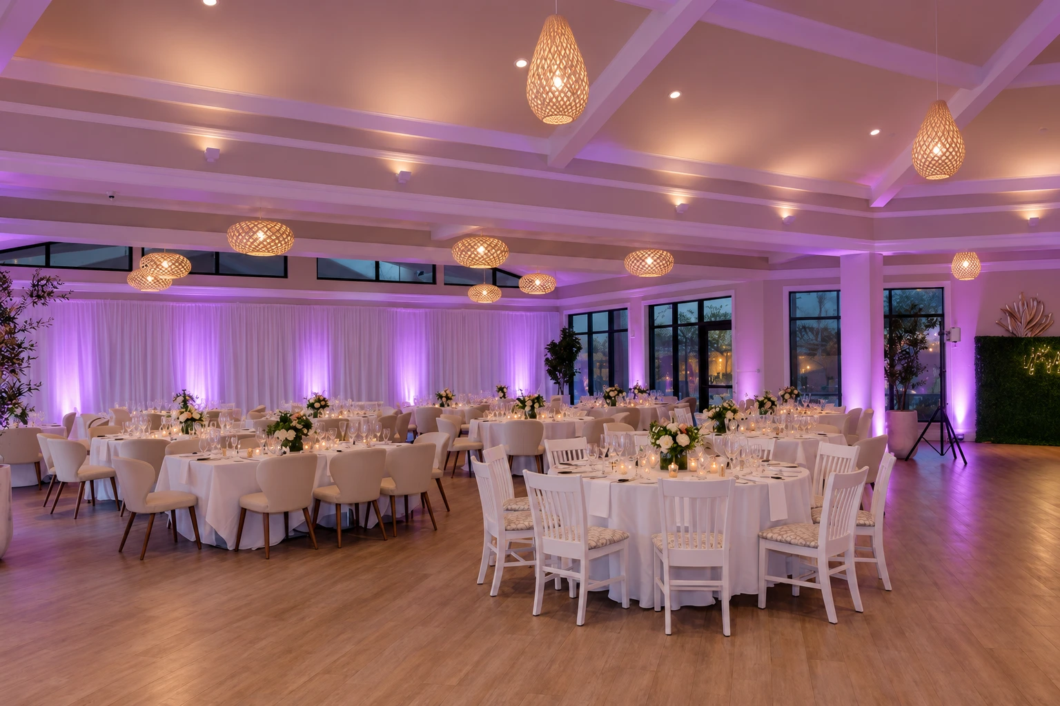 The reception room with lavender uplighting on the white draping and columns, and dimmed ambient lighting.