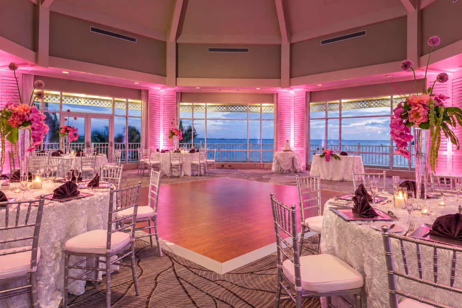 Waterfront reception room with pink uplighting on the columns and perimeter.